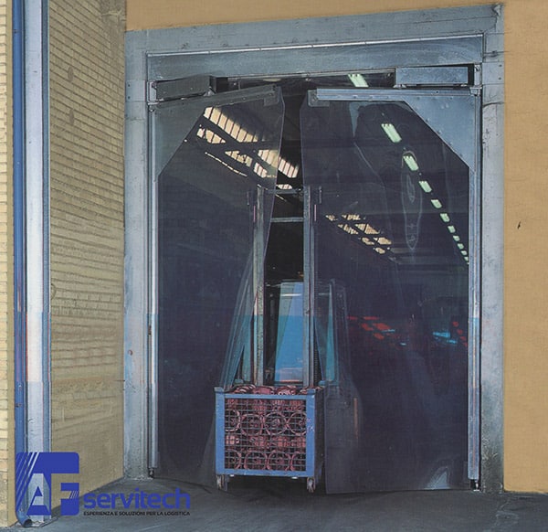 porte-flessibili-industriali-bologna-modena|chiusura-a-bracci-con-molla|installazione-porte-industriali-a-battente-bologna|porte-flessibili-industriali-a-battente-modena|portoni-a-battente-in-pvc-trasparente-bologna|prezzi-portoni-flessibili-a-battente-modena|sistema-di-apertura-automatico|struttura-portante-in-acciaio-zincato